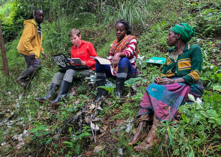 Marie interviewing farmers on hillside in Rwanda